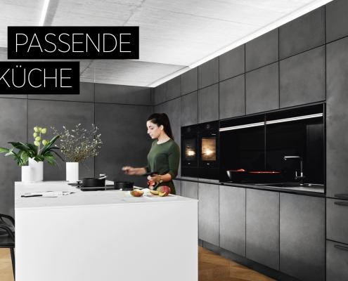 Modern designer kitchen with black fronts and cooking island. High-quality materials such as marble and matt cabinet elements give the open kitchen a minimalist, luxurious look.